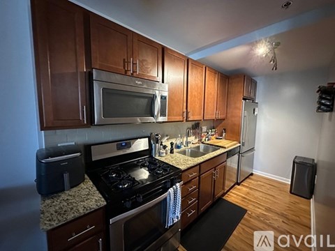 A kitchen with wooden cabinets and a granite countertop.