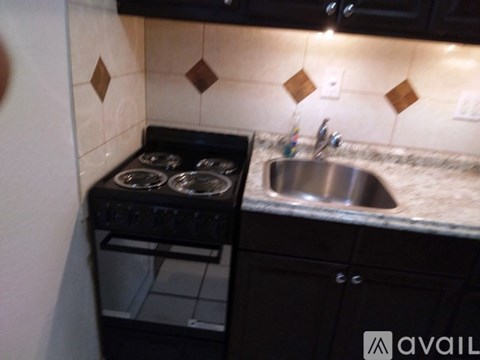 A kitchen with a stove top oven and a sink.