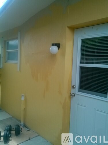 A yellow wall with a white door and window.