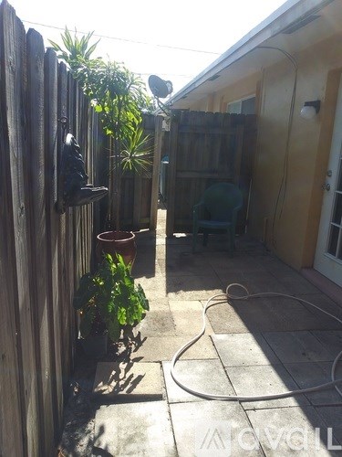 A patio with a chair and a table with a plant on it.
