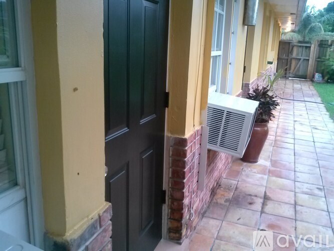 A black door is on the left and a white air conditioner is on the right.