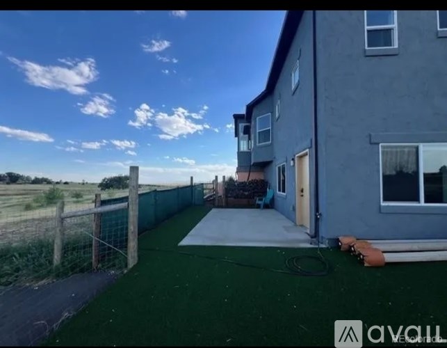 A house with a grey exterior and a green lawn.