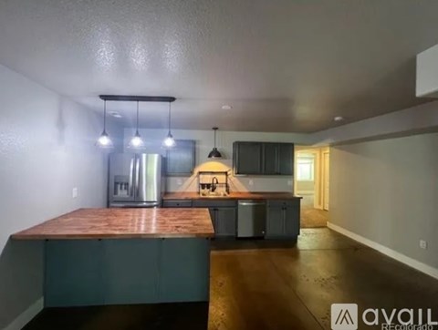 A kitchen with a wooden countertop and a stainless steel refrigerator.