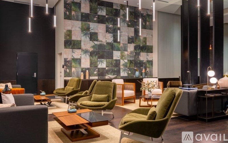 A modern living room with green chairs and a patterned wallpaper.