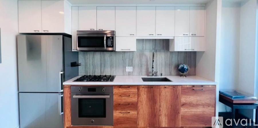 A kitchen with wooden cabinets and a stainless steel refrigerator.