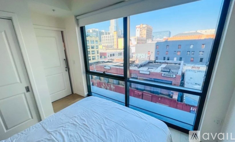 A bedroom with a large bed and a view of the city.