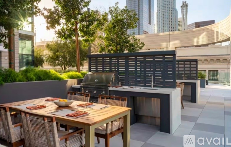 A table set for a meal on a patio with a city skyline in the background.