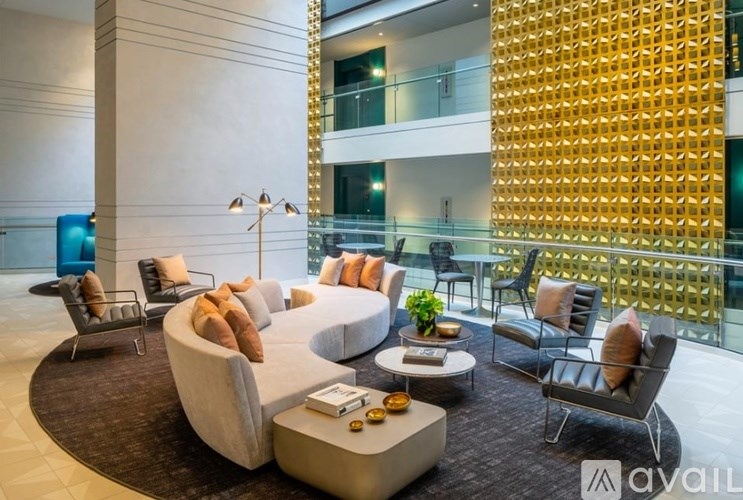 A modern living room with a large circular sofa and a glass balcony.