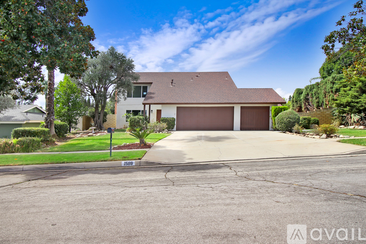 A house with a brown roof and a driveway in front of it.