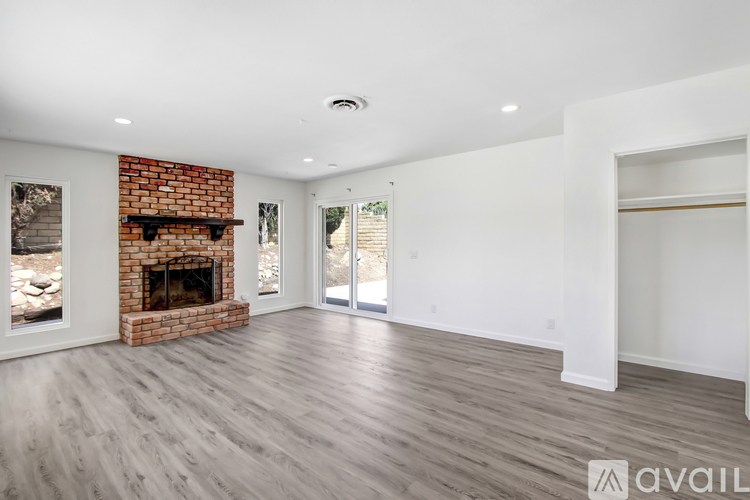 A spacious living room with a fireplace and sliding glass doors.