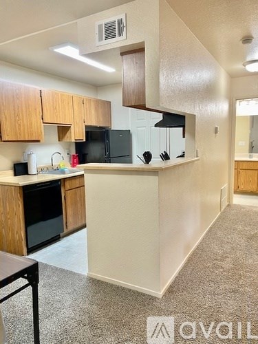 A kitchen with wooden cabinets and black appliances.