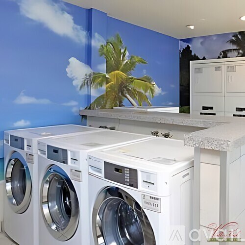 A row of white front load washing machines in a laundromat.