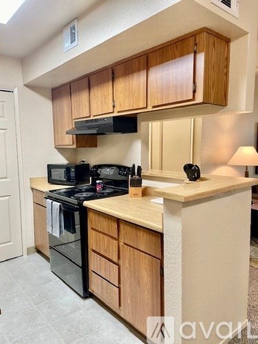 A kitchen with wooden cabinets and black appliances.
