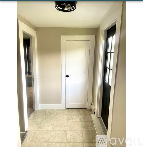 A white door is in the middle of a hallway.