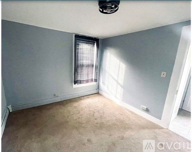 A room with a window and a ceiling fan.