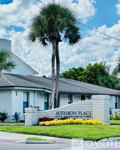A sign in front of a house that says "Audubon Place" and "Gulf Condominiums".