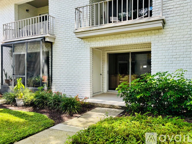 A white building with a balcony and a door.