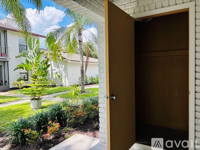 A wooden door is open to a garden.