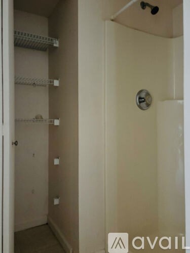 A small, empty closet with a white door and a white shelf.