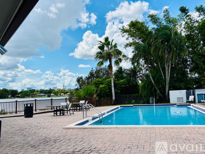 A pool surrounded by trees and a clear sky.