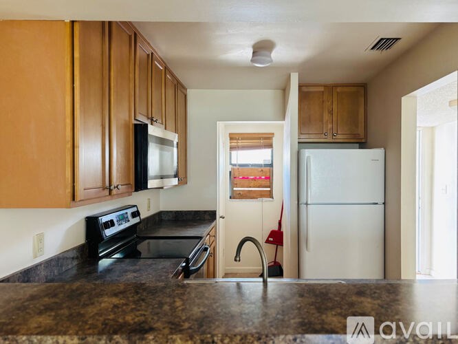 A kitchen with wooden cabinets and a black countertop.