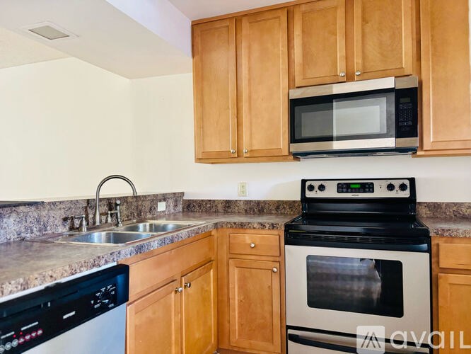 A kitchen with a black oven and wooden cabinets.