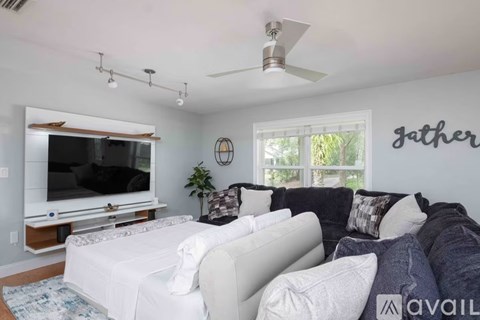 A living room with a white couch and a television.
