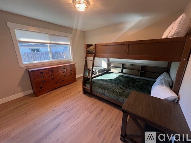 A bedroom with a bunk bed and a dresser.