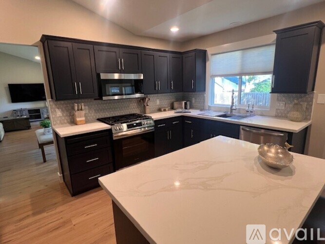 A kitchen with dark wood cabinets and a white countertop.