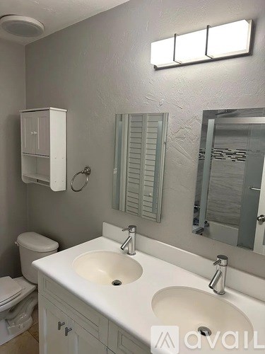 A bathroom with a white sink and a toilet.