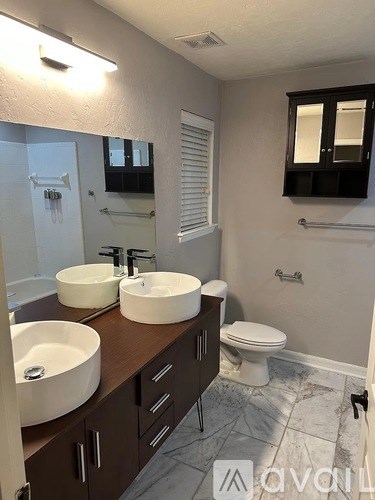 A bathroom with two sinks and a toilet.