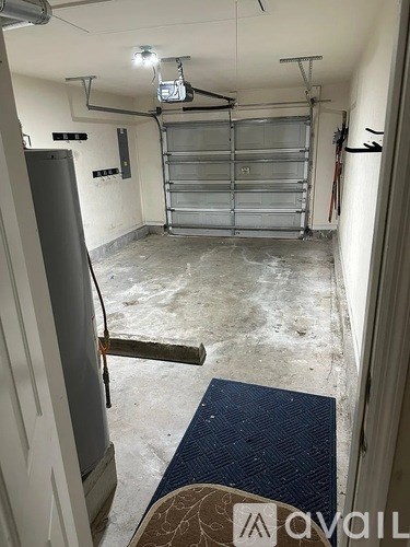 A room with a closed metal gate and a door on the left side.