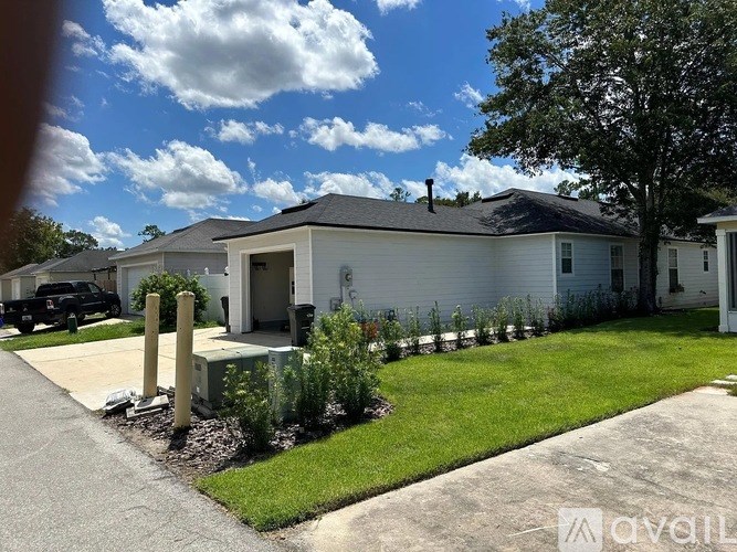 A white house with a black car parked in front.