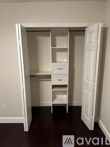 A white closet with drawers and shelves is open.