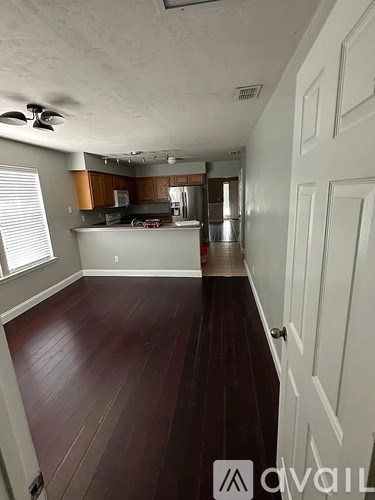 A room with wooden floors and a ceiling fan.