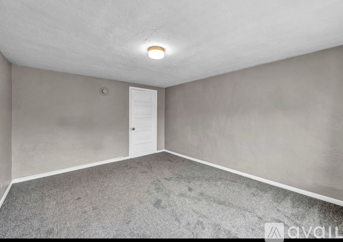 A room with a door and a light on the ceiling.