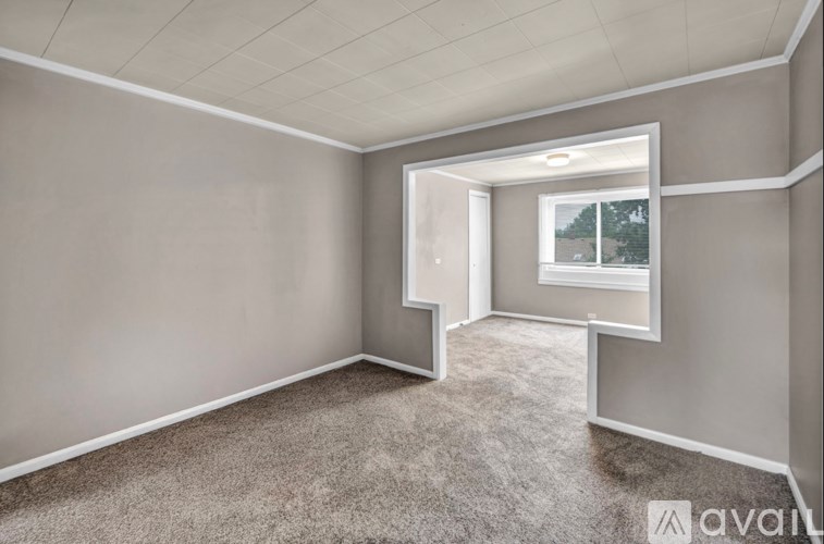 A room with a carpeted floor and a window.