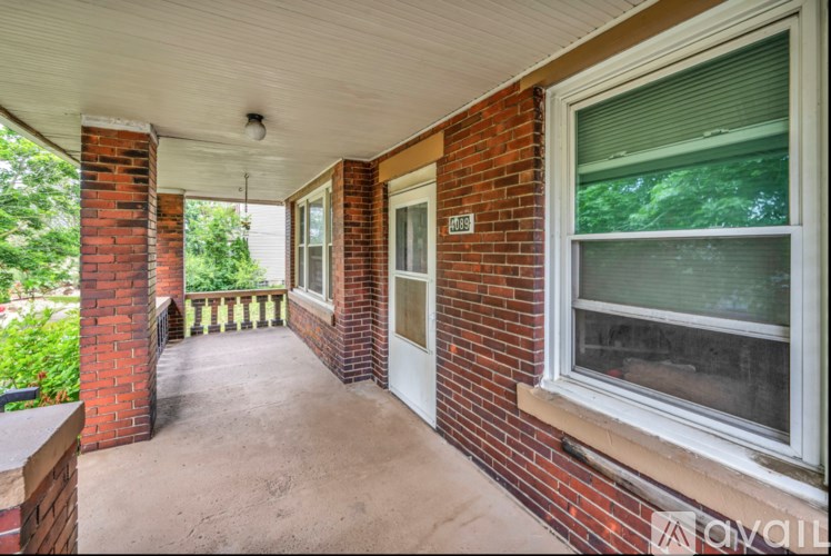A porch with a white door and a window with blinds.