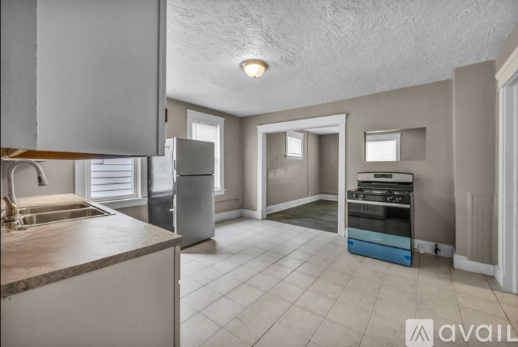 A kitchen with a sink, a refrigerator, and a stove top oven.