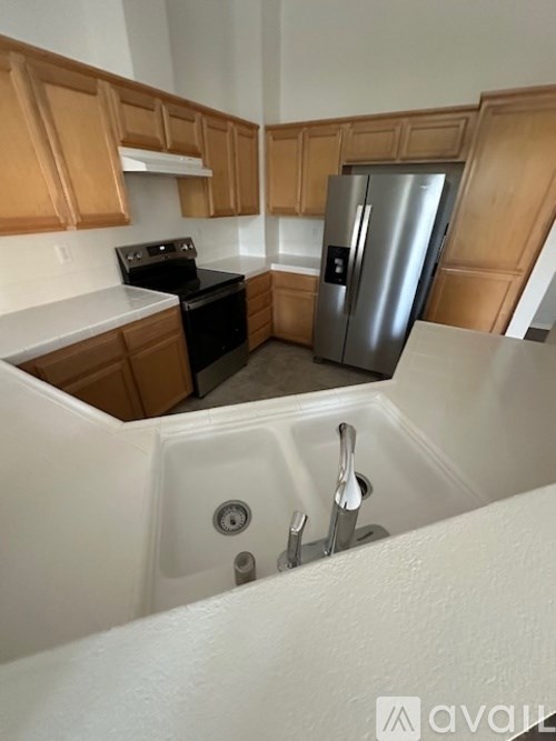 A kitchen with wooden cabinets and a stainless steel refrigerator.
