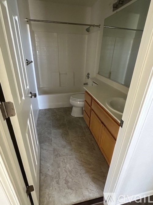 A white bathroom with a toilet, sink, and shower.