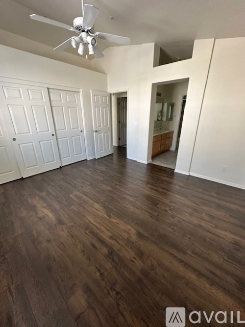 A room with wooden floors and a ceiling fan.