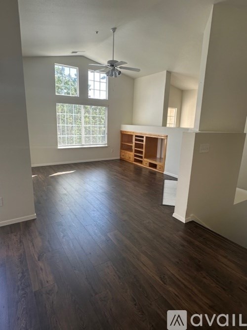 A room with wooden floors and a window with blinds.
