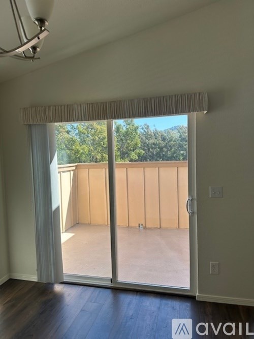 A room with a sliding glass door leading to a balcony.