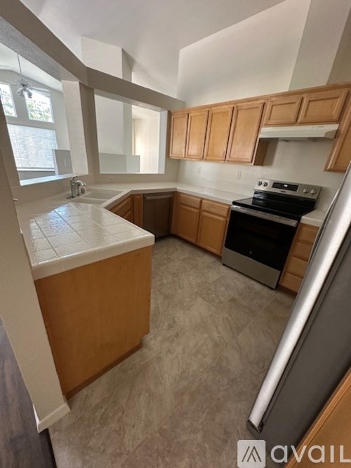 A kitchen with wooden cabinets and a tiled backsplash.