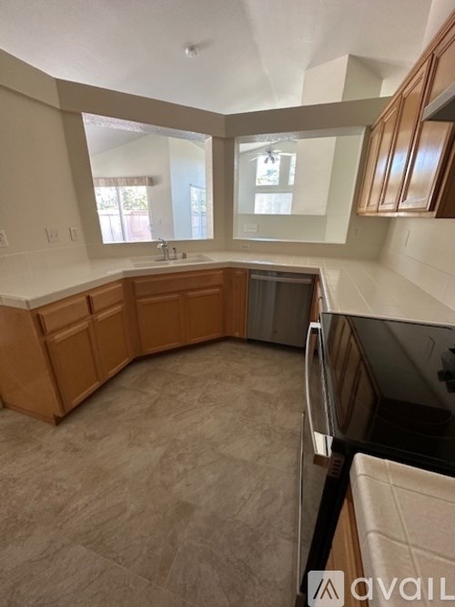 A kitchen with wooden cabinets and a tiled floor.