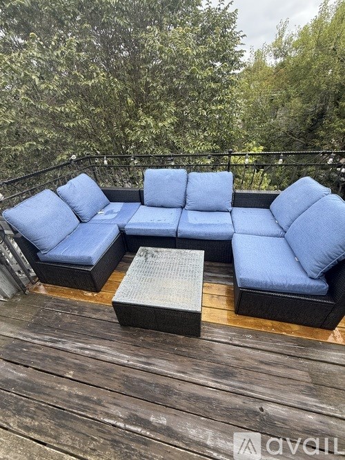A blue couch set on a wooden deck.