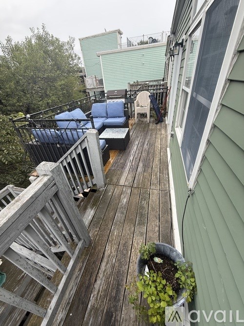 A wooden deck with a planter and chairs.
