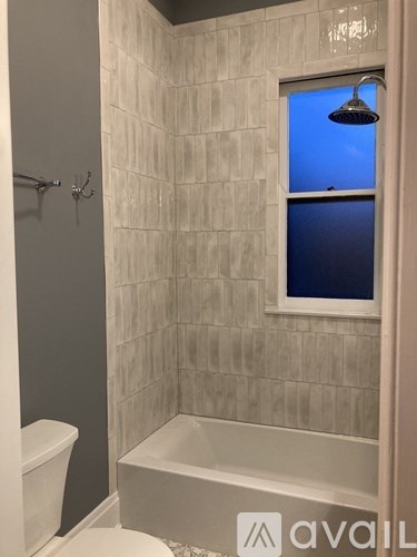 A bathroom with a white tub and toilet.