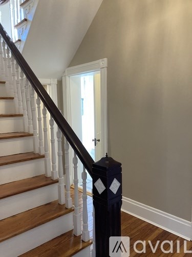 A staircase with a wooden handrail and white balusters.